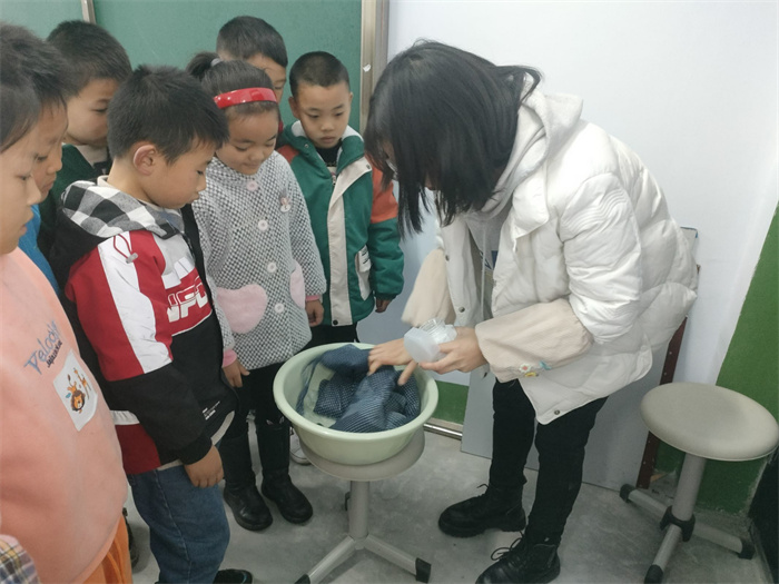 老师教低龄留守儿童们学习独立做家务:洗衣服.jpg 老师教低龄留守儿童们学习独立做家务:洗衣服.jpg