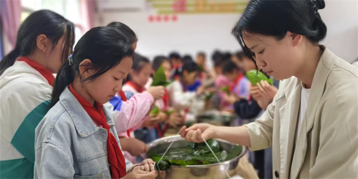 孩子们在老师的指导下包粽子.jpg 孩子们在老师的指导下包粽子.jpg